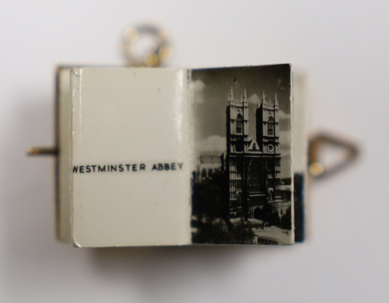 An enamelled 9ct gold photograph album charms with views and crest of London, 1.5cm gross 3.1 grams